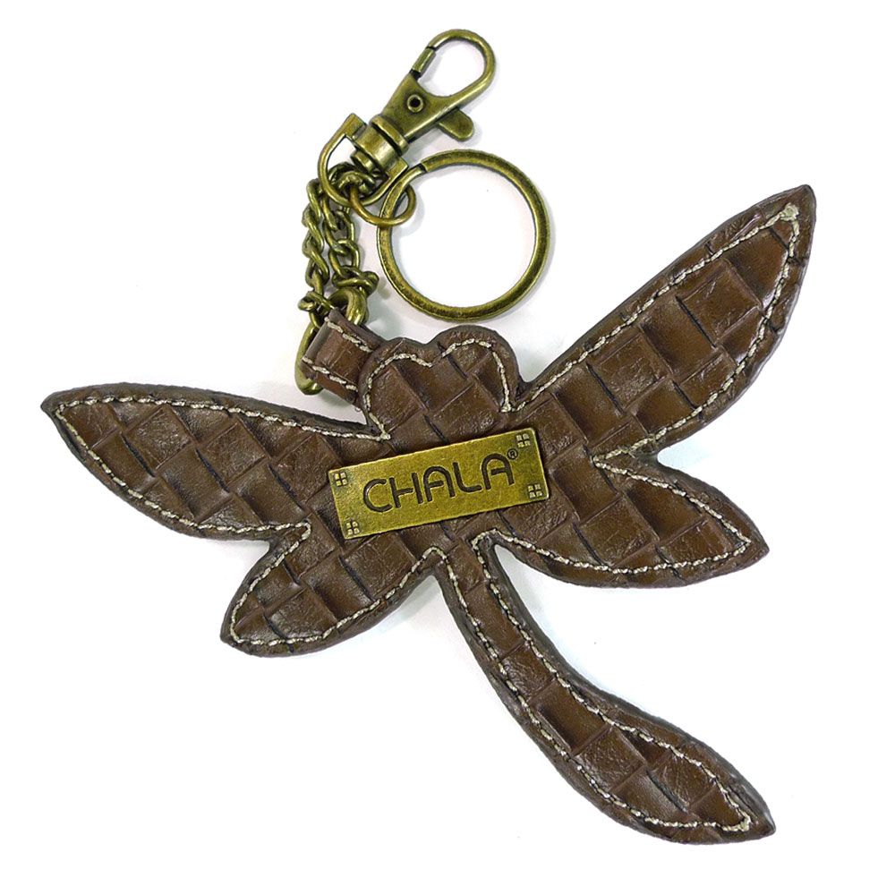 The Dragonfly Keychain from Chala features a woven texture with faux leather trim and intricate stitching. It includes a brass-colored label displaying the brand name "CHALA" and comes with a brass clip and keyring.