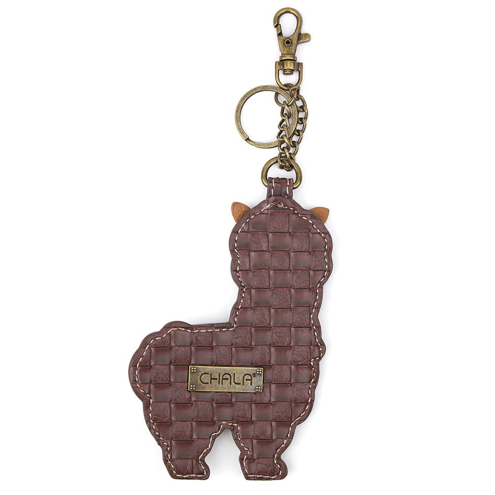 The Chala Llama Keychain is an adorable accessory designed in the shape of a llama, made from textured faux leather. It features a brass-colored metal tag engraved with "CHALA" and includes antique brass hardware such as a durable clasp and keyring.