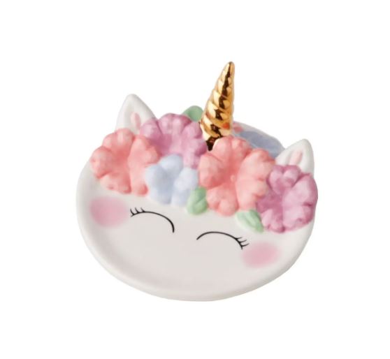 Introducing the Unicorn Trinket Dish by Streamline: a charming ceramic dish shaped like a unicorn face, complete with a golden horn, blushing cheeks, closed eyes, and pastel-colored flowers adorning its head. This delightful piece is perfect for holding your favorite jewelry accessories.