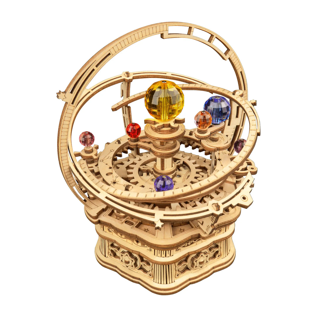 The DIY Starry Night Mechanical Music Box by Hands Craft is a detailed wooden model featuring intricate gears, arches, and ornate designs that symbolize the mechanics of the solar system. This colorful DIY kit includes spheres representing celestial bodies, such as a large yellow sphere surrounded by smaller red and blue ones.