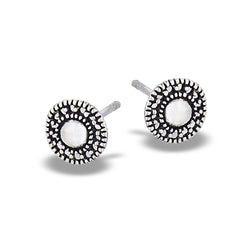 The Welman Round Bali Style Granulated Silver Stud earrings feature intricate beaded detailing around the edges and a smooth, polished center. Designed with short posts for mask-friendly fastening, these elegant studs boast a vintage-inspired look.