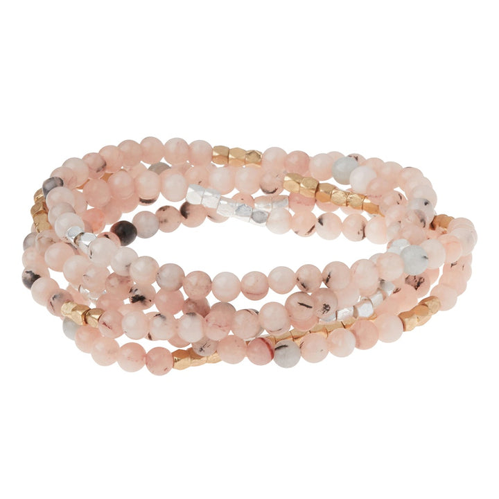 The Stone Wrap Morganite/Blk Tourmaline by Scout Jewelry is a striking bracelet set featuring semi-precious gemstones, with pink, gold, and silver beads in various textures and shades, elegantly stacked for a chic look.