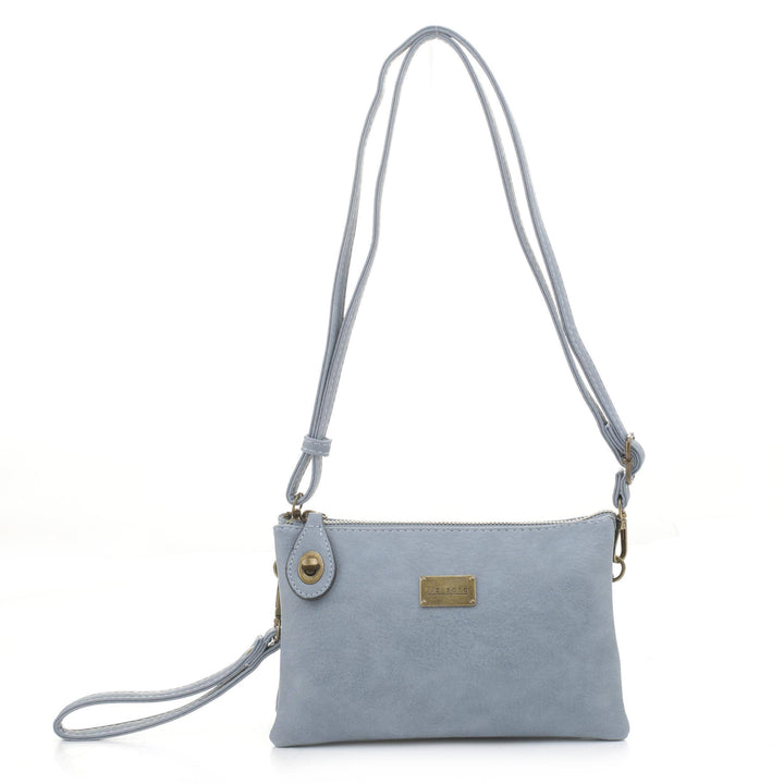 The Tina Cell Bag - Blue by Liz Soto Handbags is a light blue leather crossbody bag that comes with a long, adjustable strap. This stylish, small handbag showcases a zipper closure, a small golden logo plate on the front, and an attached wristlet strap on one side. It is displayed on a plain white background.