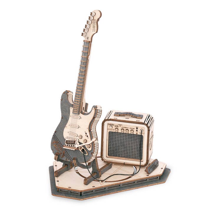 Introducing the next piece in our Musical Instrument Series: the Hands Craft "Laser Cut Wooden Puzzle: Electric Guitar." This detailed kit features an electric guitar with a stand and a small amplifier. The guitar includes intricate strings and fretboard details, while the amplifier boasts realistic knobs and a mesh front. All components are set on a geometric base.